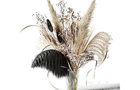 Bouquet of dried flowers with a black feather in a glass vas